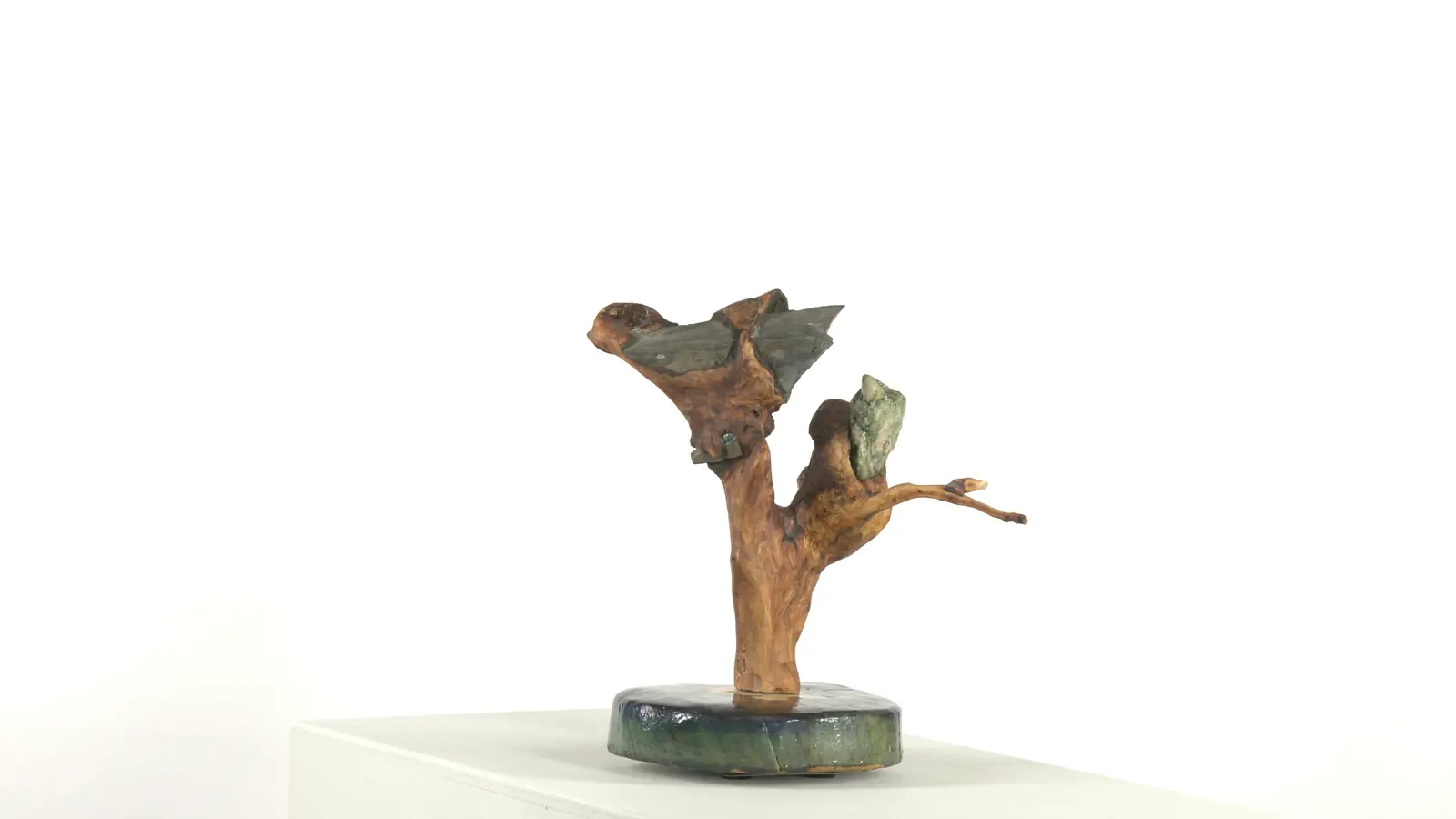Figure animale — forme bondissante (oiseau / félin) sculptée dans bois torturé, pierre verte encastrée, base ronde peinte. — vue 1