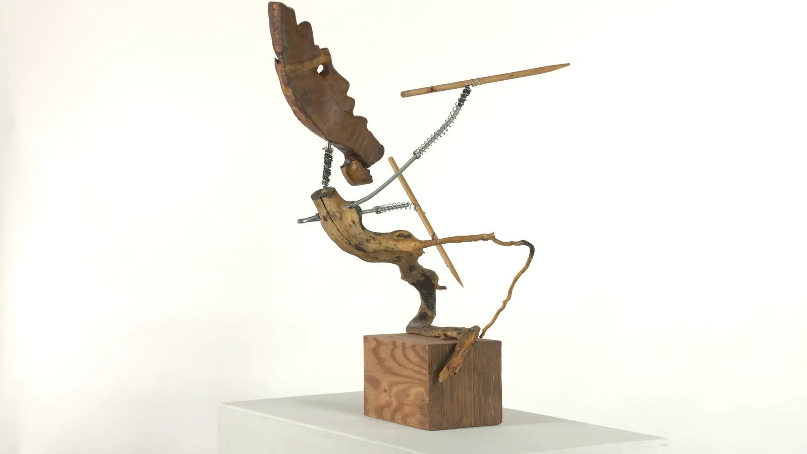 Chasseur archaïque — tête animale (cervidé / loup) en bois sculpté, cou en ressort métallique, bras tendu avec lance, corps en bois trouvé tortueux. — vue 2