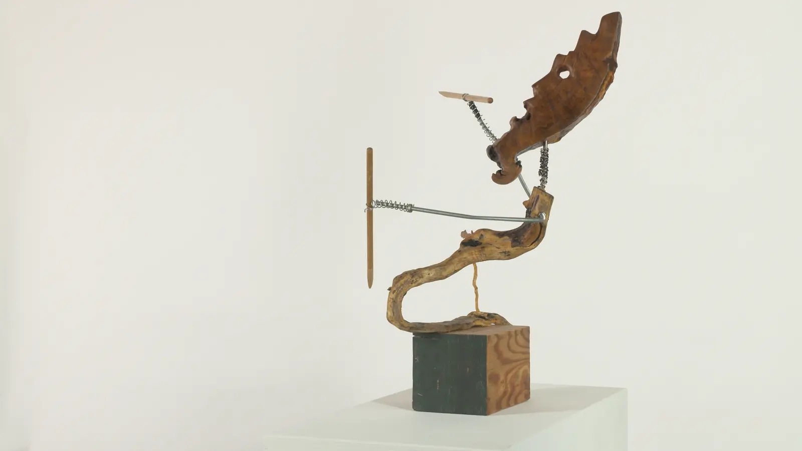 Chasseur archaïque — tête animale (cervidé / loup) en bois sculpté, cou en ressort métallique, bras tendu avec lance, corps en bois trouvé tortueux. — vue 3