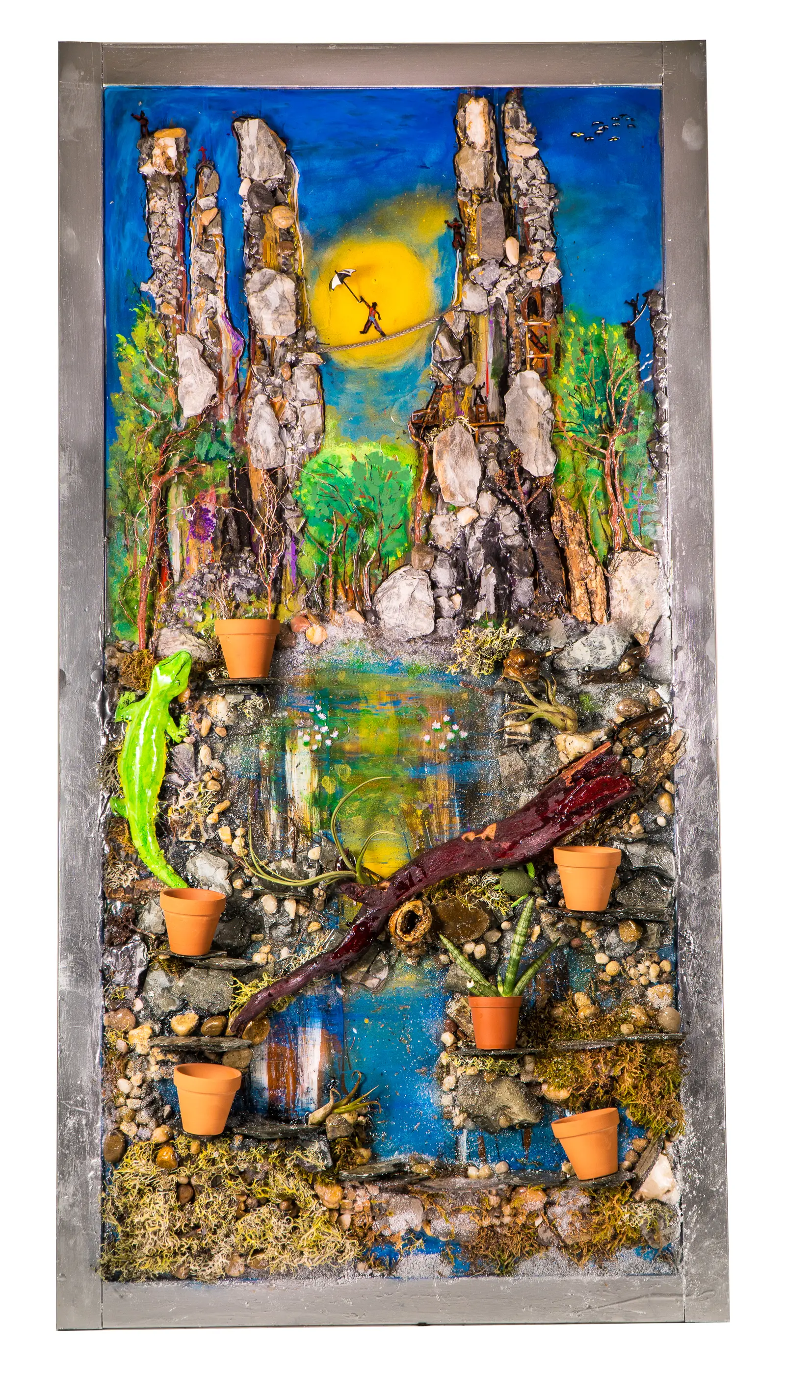 Salamandre, photo de studio (état antérieur avec pots de terre cuite intégrés au relief) : falaises de pierre et bassin sous un soleil jaune, salamandre verte sur la berge