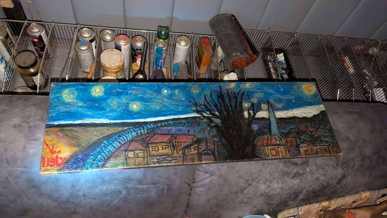 Vue d'atelier de « La suite de la Nuit étoilée » posée sur un canapé, donnée comme référence d'échelle : le long panneau de bois horizontal occupe presque toute la largeur de l'assise. Signature « Van Ugly » visible en bas à gauche.