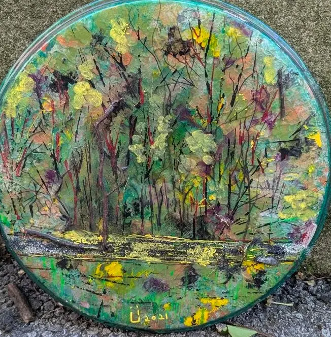 Tondo peint sur peau de tambour : sous-bois dense en verts et jaunes, troncs grêles, étang au bas du cercle, signé Ü 2021, œuvre de Robert Bibeau